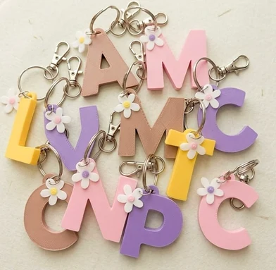 Llaveros de iniciales en colores pastel con margaritas